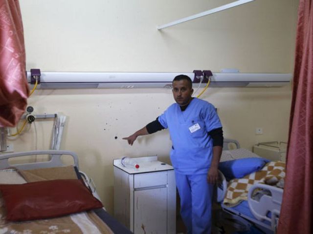 a medic shows to journalists a bullet hole in a wall surrounded by blood stains of a palestinian man who was killed by israeli undercover forces during a raid at al ahly hospital in the west bank city of hebron november 12 2015 photo reuters