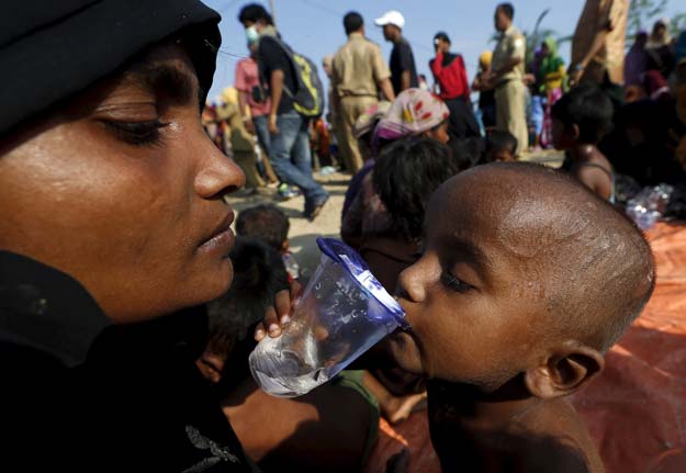 a rohingya migrant mother watches as her child drinks water after they arrived by boat at the port of julok village in kuta binje indonesia 039 s aceh province may 20 2015 photo reuters