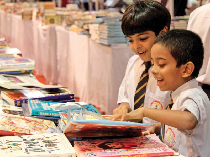 children check out books at a stall at karachi s expo centre on friday the five day book fair ends on monday photo aysha saleem express