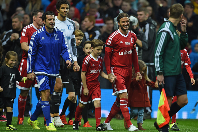 david beckham and luis figo lead their teams out ahead of a charity football match between a great britain and ireland team and a rest of the world team at old trafford in manchester on november 14 2015 photo afp