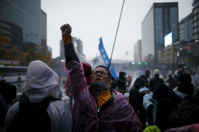 a protester reacts as water mixed with tear gas liquid is sprayed by police water canon to disperse protesters during an anti government rally in central seoul south korea november 14 2015 photo reuters