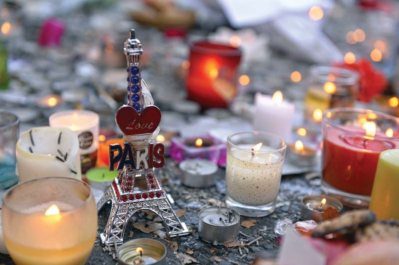 candles and a miniature eiffel tower are placed at a memorial near the bataclan concert hall photo afp