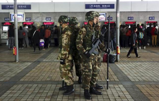 armed paramilitary policemen stand guard next to train ticket booths after a knife attack last saturday at kunming railway station in kunming yunnan province march 7 2014 photo reuters