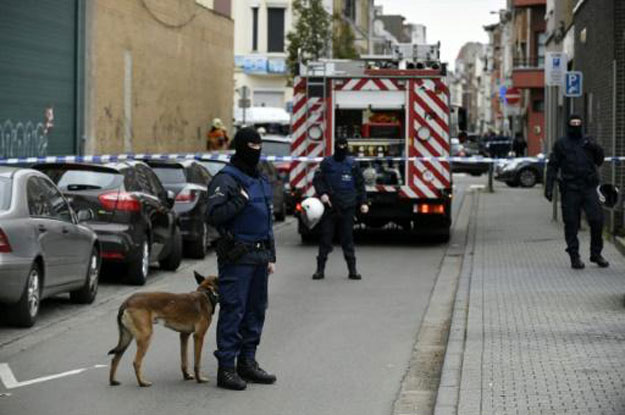 police officers look on as an operation takes place in the molenbeek district of brussels on november 16 2015 photo afp