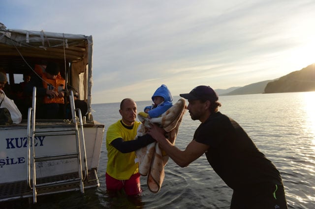 migrants and refugees arrive on the greek island of lesbos after crossing the aegean sea from turkey on november 16 2015 photo afp