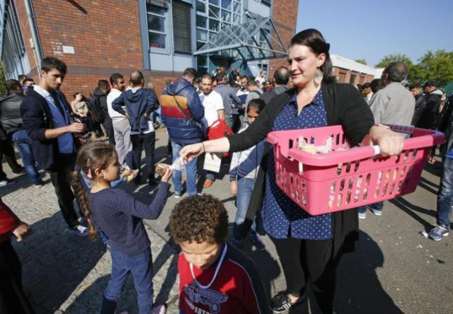 a volunteer distributes food to migrant children in front of the federal office for migration and refugees at berlin 039 s spandau district germany photo reuters