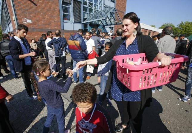 a volunteer distributes food to migrant children in front of the federal office for migration and refugees at berlin 039 s spandau district germany photo reuters