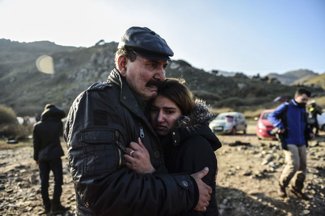 a man hugs her daughter after arriving on the greek island of lesbos along with other migrants and refugees on november 17 2015 photo afp