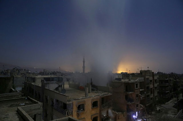 smoke billows from a building early on october 30 2015 following reported shelling by syrian government forces in the rebel controlled area of douma east of damascus photo afp