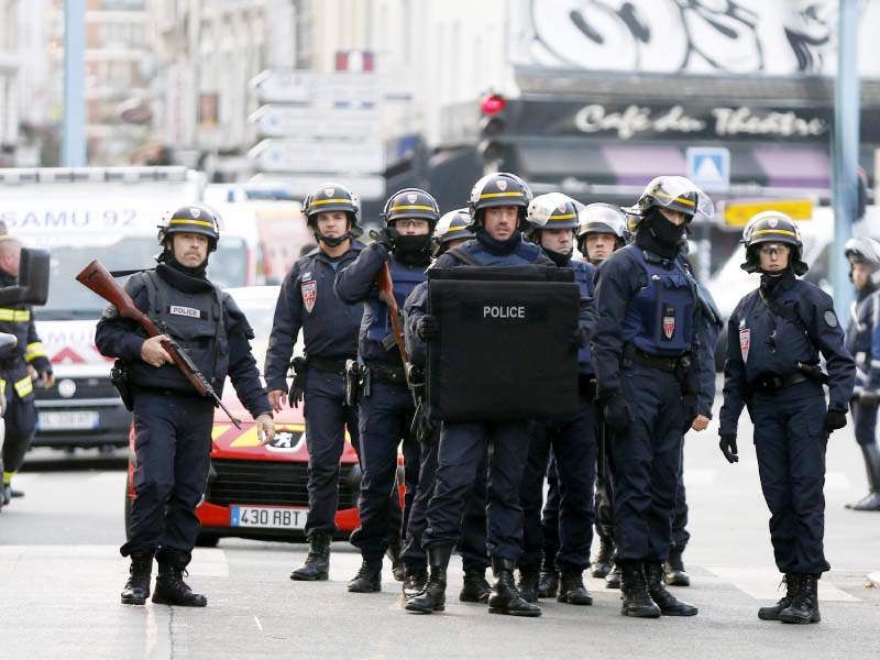 policemen stand guard in paris as special forces raid an apartment photo afp