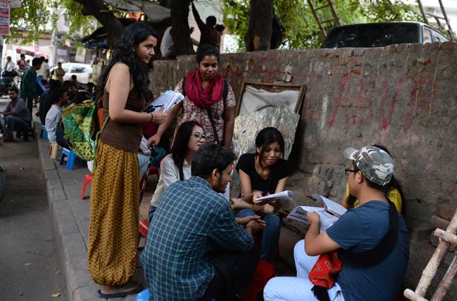 indian student activists shambhawi vikram l and shriya subhashini c speak to fellow students as they distribute leaflets outside delhi university 039 s north campus in new delhi photo afp