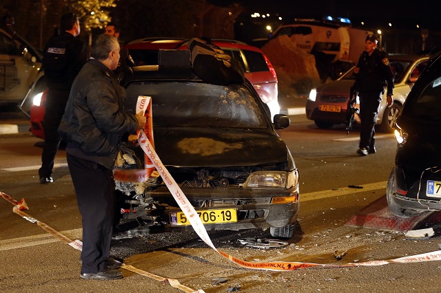 an israeli forensic expert stands next to a car at the site of an attack that left one israeli dead and eight wounded in the jewish settlement bloc of gush etzion south of jerusalem in the israeli occupied west bank on november 19 2015 photo afp