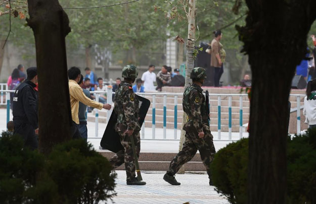paramilitary police patrol beside the central square in hotan in china 039 s western xinjiang region photo afp