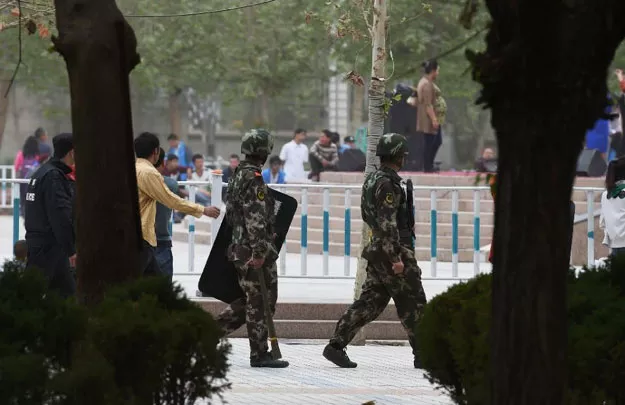 paramilitary police patrol beside the central square in hotan in china 039 s western xinjiang region photo afp paramilitary police patrol beside the central square in hotan in china 039 s western xinjiang region photo afp