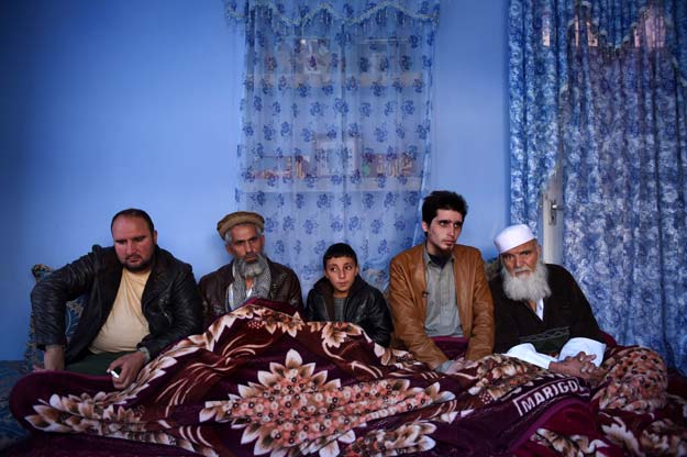 to go with story 039 afghanistan unrest focus 039 by guillaume decamme in this photograph taken on november 17 2015 former islamic state hostage mohammed yousuf 23 2r sits with relatives during an interview with afp in kabul held for nine months by fighters claiming to be from islamic state and freed not by afghan or nato soldiers but by the taliban mohammed yousuf 039 s blue eyes evoke the horror he is trying to blot out photo afp