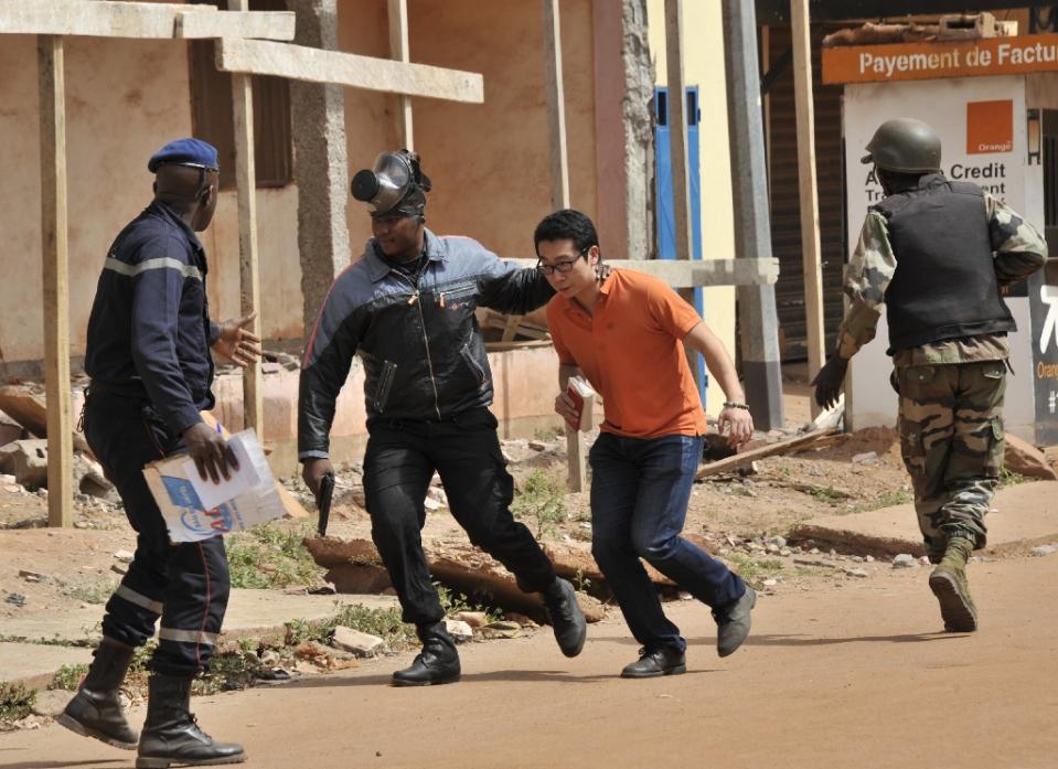 malian security forces evacuate a man from near the radisson blu hotel in bamako on november 20 2015 photo afp