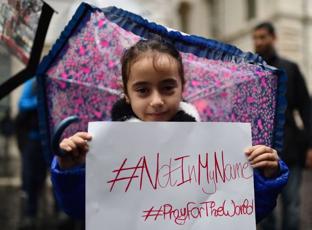 a little girl shows a placard reading quot not in my name quot during a demonstration of muslims to speak out against terrorism a week after paris attacks on november 21 2015 in rome photo afp