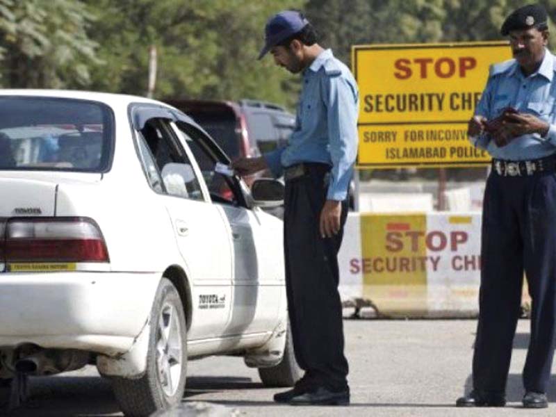 a policeman checks a car at a security check point in islamabad photo file