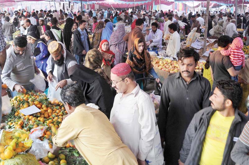 people buying fruit and vegetables at a market on sunday photo express