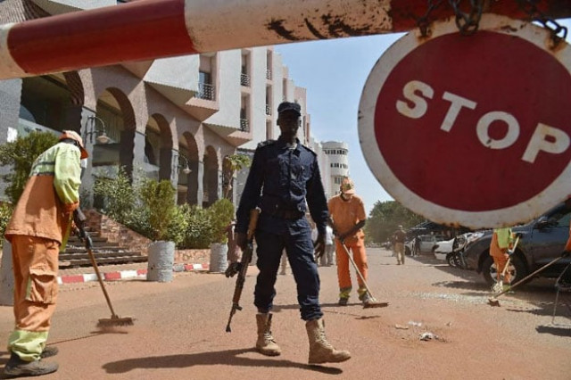 a malian police officer stands guard as municipal workers clean outside the radisson blu hotel in bamako on november 22 2015 two days after a deadly attack photo afp a malian police officer stands guard as municipal workers clean outside the radisson blu hotel in bamako on november 22 2015 two days after a deadly attack photo afp