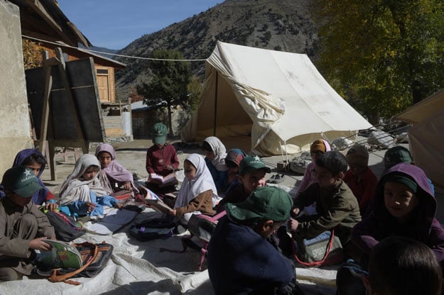 in this photograph taken on october 31 2015 pakistani children attend a class outside an earthquake damaged school in brun village of the bumburate valley photo afp