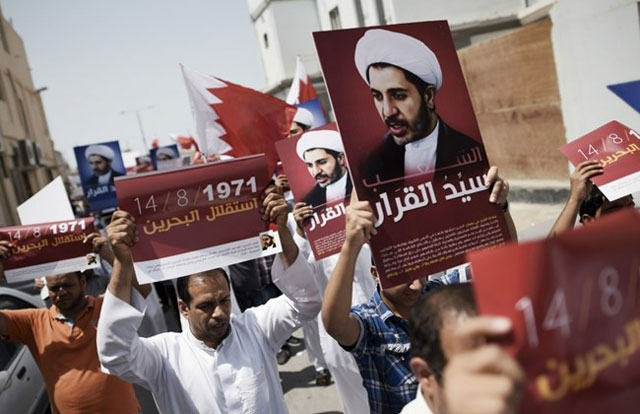 bahraini protesters hold placards bearing the portrait of sheikh ali salman head of the shia opposition movement al wefaq during a demonstration against his arrest and to mark bahrain 039 s independence day on august 14 2015 in the village of diraz west of the capital manama photo afp