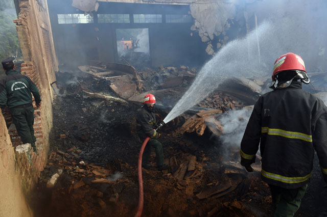 pakistani firefighters extinguish a fire at a factory after it was torched by an angry mob in jehlum on november 22 2015 photo afp