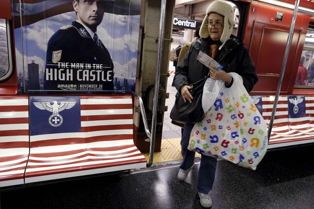 passengers board a 42nd street shuttle subway train wrapped with advertising for the amazon series quot the man in the high castle quot in the manhattan borough of new york november 24 2015 new york city mayor bill de blasio on tuesday called on amazon com inc to remove quot irresponsible and offensive quot subway advertisements for a new television show featuring nazi inspired imagery the advertisements for quot the man in the high castle quot include a version of the american flag with a german eagle and iron cross in place of the stars as well as a stylized flag inspired by imperial japan photo reuters