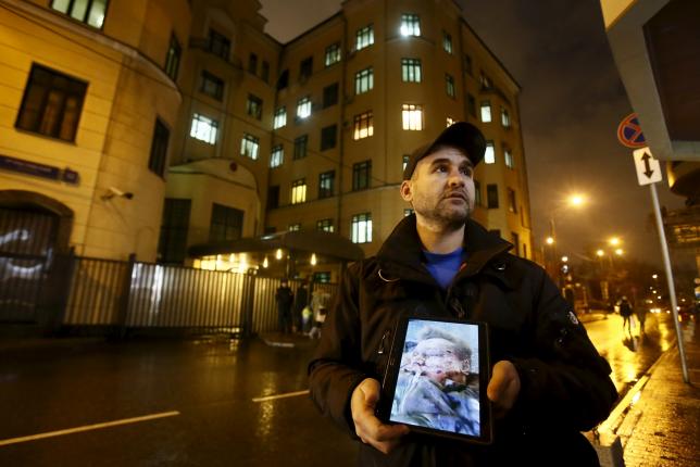 an activist holds a tablet with a picture of the lifeless body of a russian pilot of a war plane shot down by turkey in front of the turkish embassy in moscow russia november 24 2015 photo reuters