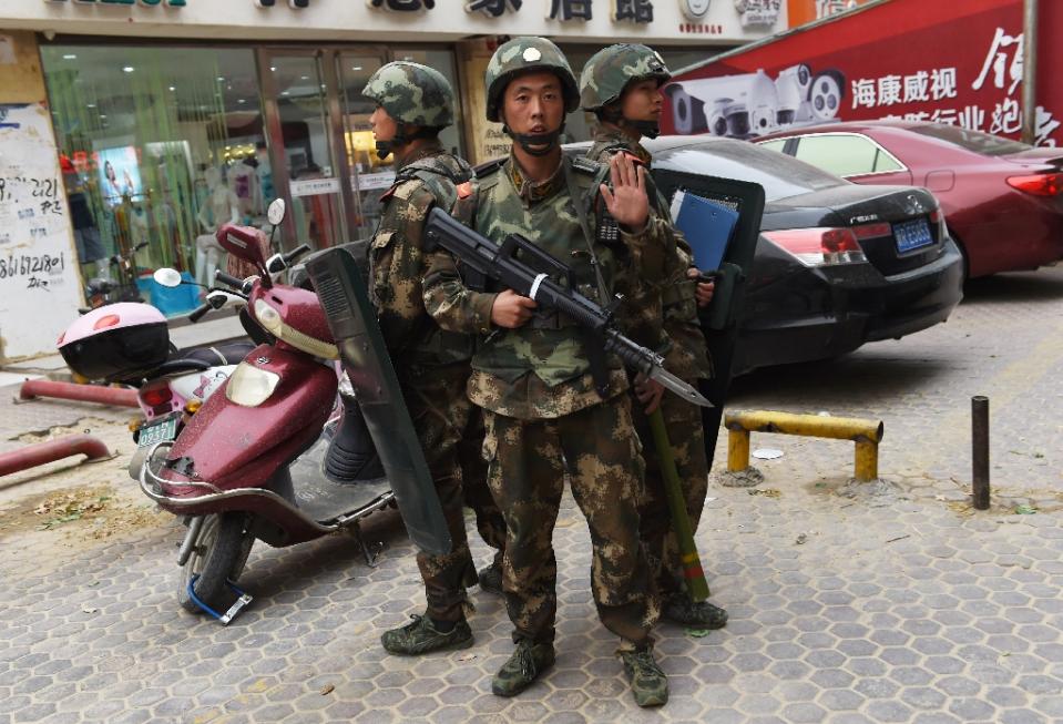 paramilitary police stand guard outside a shopping mall in hotan in china 039 s western xinjiang region on april 16 2015 photo afp