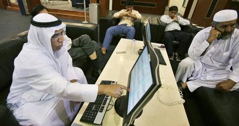 an investor gestures to an electronic display board at the dubai international financial market photo reuters