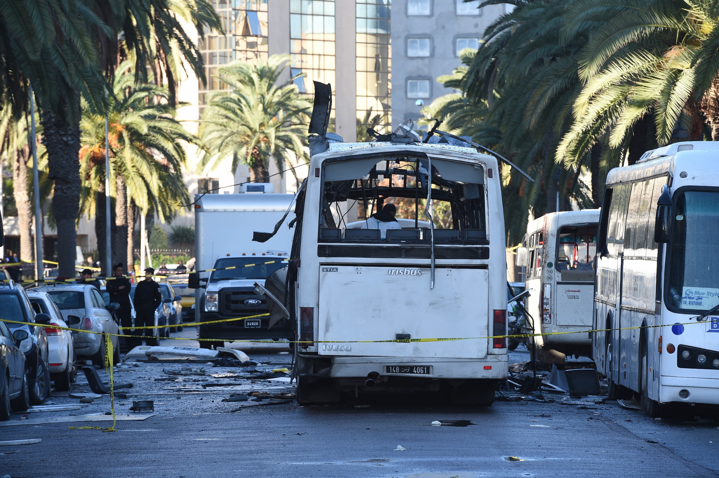 tunisian forensic police inspect the wreckage of a bus in the aftermath of a bomb attack on the vehicle which was transporting tunisia 039 s presidential guard in central tunis on november 25 2015 photo afp