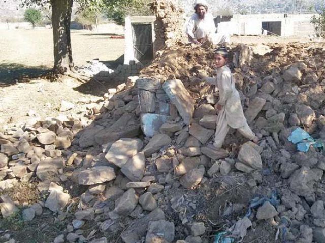 a boys stand on the debris of a house in salarzai bajaur agency photo express