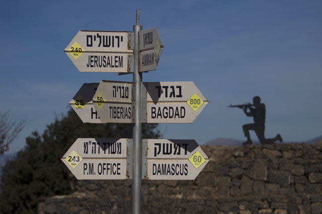 a sculpture of an israeli soldier standing guard is seen on november 25 2015 next to a sign for tourists showing the distance to damascus and baghdad at an army post on mount bental in the israeli annexed golan heights in the area from which an israeli arab reportedly paraglided into syria to join an islamic state affiliated group photo afp