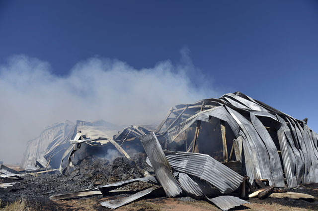 smoke rises from a burning godown used for dry fodder following bushfires in freeling north of adelaide on november 26 2015 photo afp