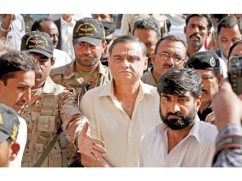 rangers escort dr asim hussain to the court for the hearing on thursday photo reuters