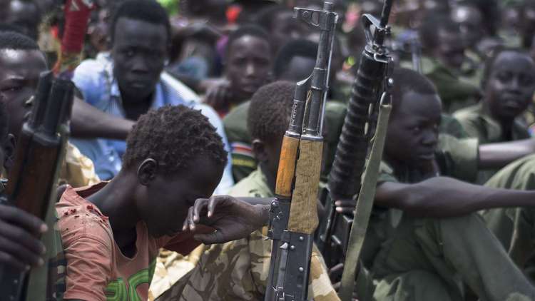 young boys sit with rifles during a child soldier disarmament demobilization and reintegration ceremony overseen by unicef on february 10 2015 in pibor south sudan photo afp