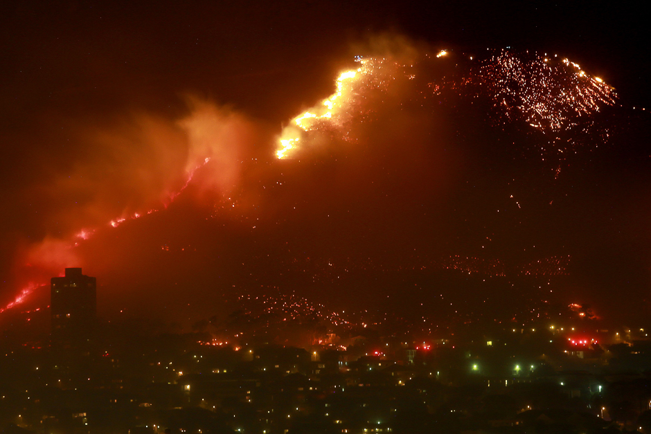 A picture taken shows a veld fire spreading on Table Mountain close to the urban side, in Cape Town. PHOTO: AFP