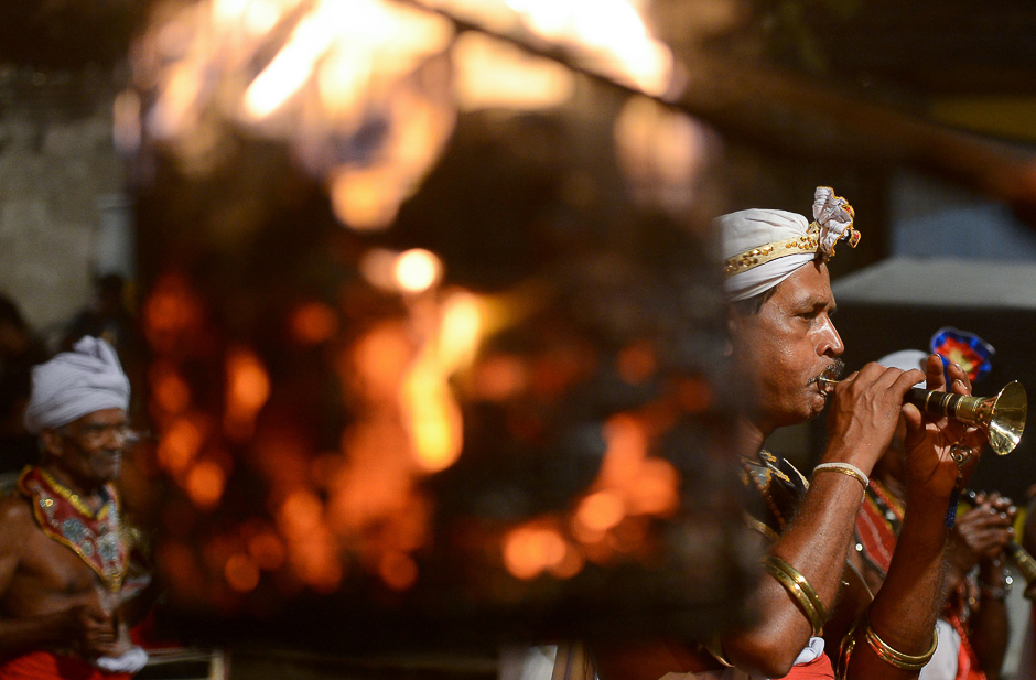 Sri Lankan traditional dancers and musicians perform in a procession in front of the Gangarama Temple. PHOTO: AFP