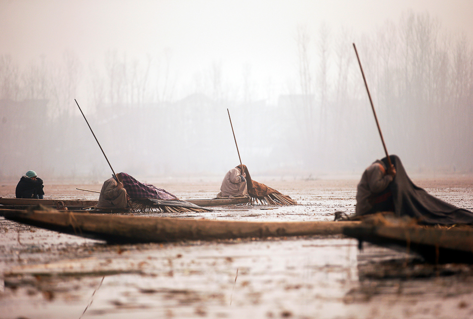 Kashmiri fishermen cover their heads and part of their boats with blankets and straw as they wait to catch fish in the waters of the Anchar Lake on a cold day in Srinagar. PHOTO: REUTERS