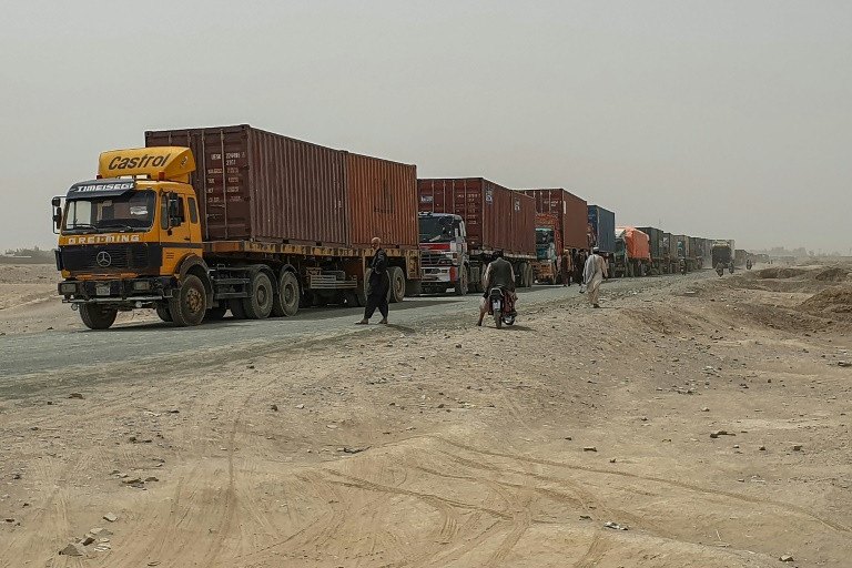 trucks carrying goods destined for afghanistan s second biggest city line up near chaman in pakistan waiting to cross the border traders say they are being taxed by the taliban as well as afghan government officials and also face extortion or robbery from highway bandits photo afp