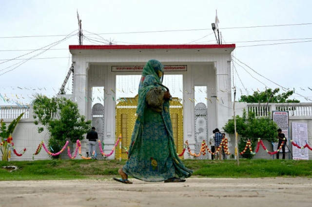 a woman walks past the ashram of preacher bhole baba at bichhawan village in mainpuri district uttar pradesh photo afp a woman walks past the ashram of preacher bhole baba at bichhawan village in mainpuri district uttar pradesh photo afp