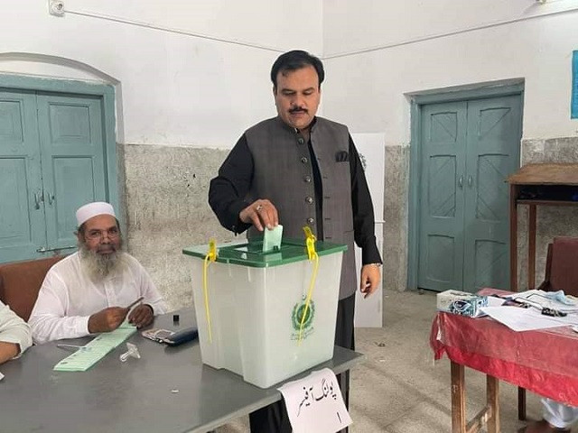 Federal parliamentary secretary, Rashid Shafiq, casts his vote in the Faiz Islam School polling centre. PHOTO: EXPRESS