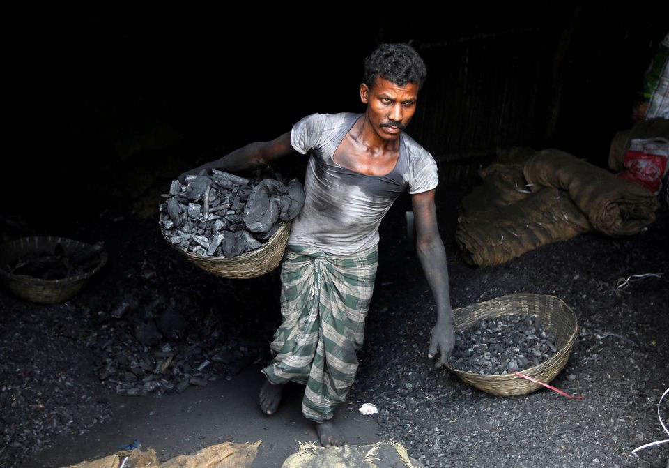 a worker carries coal in a basket in a industrial area in mumbai india photo reuters