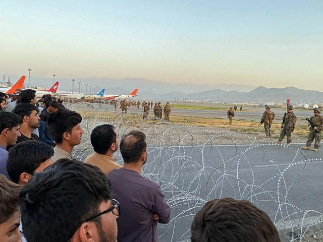afghans crowd at the airport as us soldiers stand guard in kabul on aug 16 2021 photo afp afghans crowd at the airport as us soldiers stand guard in kabul on aug 16 2021 photo afp