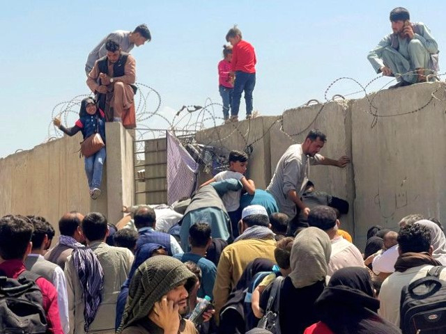 a man pulls a girl to get inside hamid karzai international airport in kabul photo reuters