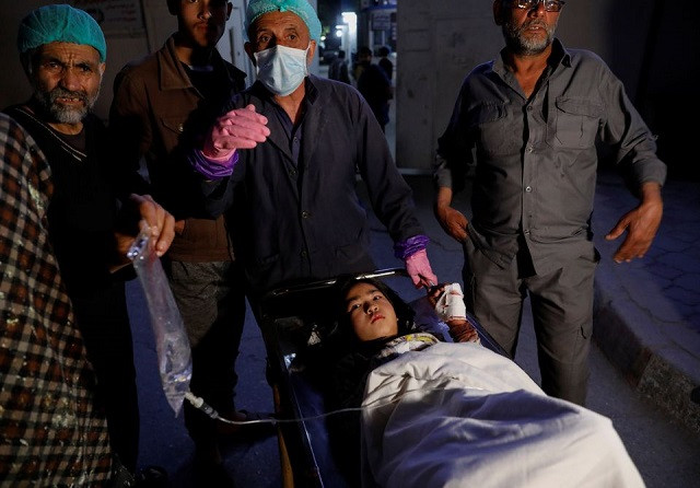 An injured school girl waits for a transport from one hospital to the other, after a blast in Kabul, Afghanistan May 8, 2021. PHOTO: REUTERS