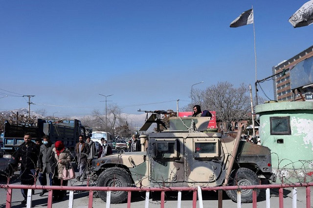 afghans walk past a humvee with a taliban fighter on it guarding the road in kabul afghanistan january 27 2022 reuters ali khara