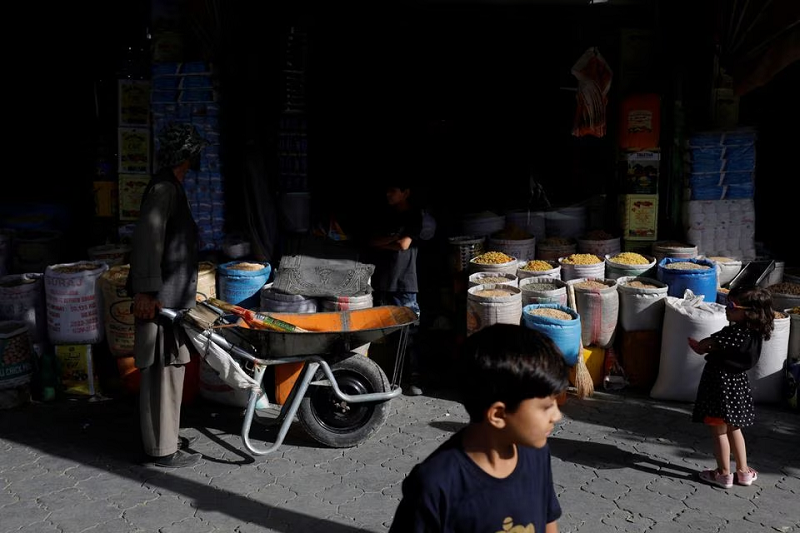 baba karim with his wheelbarrow stands next to a shop in kabul afghanistan september 3 2023 photo reuters