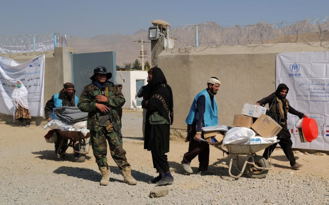 unhcr workers push wheelbarrows loaded with aid supplies for displaced afghan families as a taliban fighter secures the area outside the distribution centre on the outskirts of kabul afghanistan october 28 2021 photo reuters file unhcr workers push wheelbarrows loaded with aid supplies for displaced afghan families as a taliban fighter secures the area outside the distribution centre on the outskirts of kabul afghanistan october 28 2021 photo reuters file